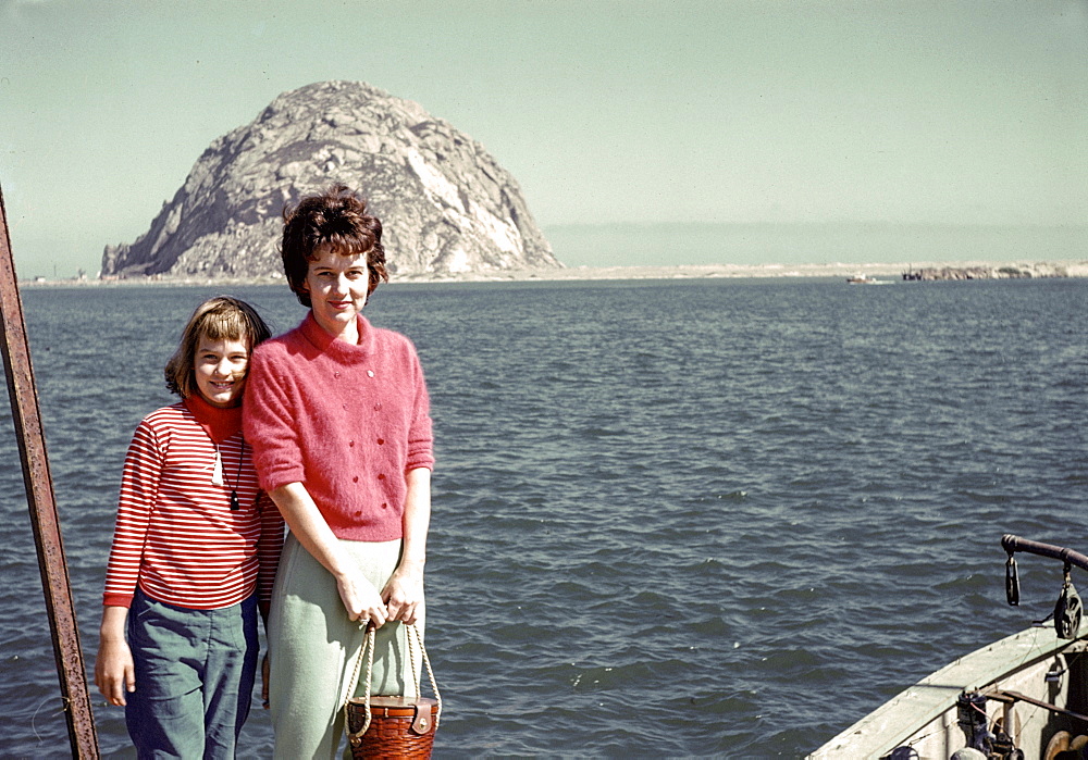 Caucasian mother and daughter posing near ocean