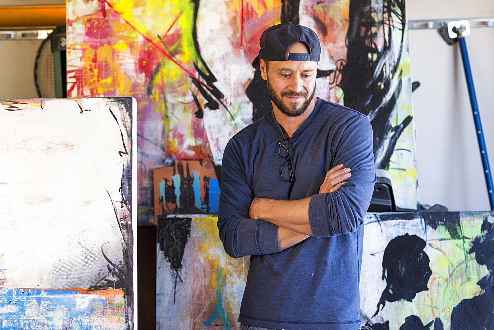 Pensive Caucasian man standing near paintings