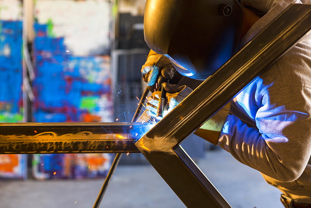 Man welding metal sculpture