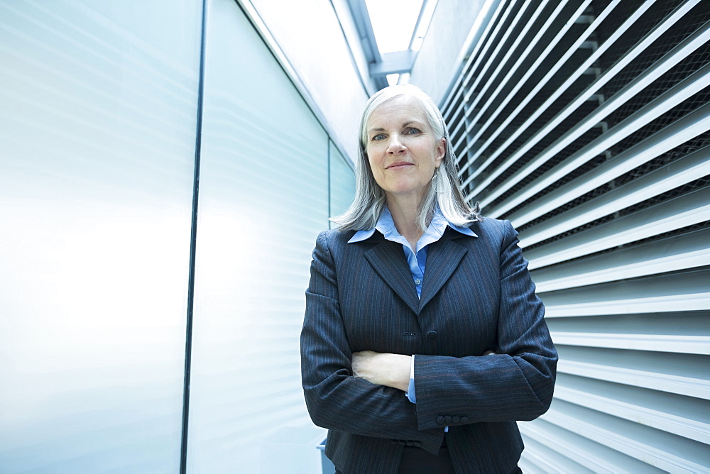 Portrait of smiling Caucasian businesswoman in corridor