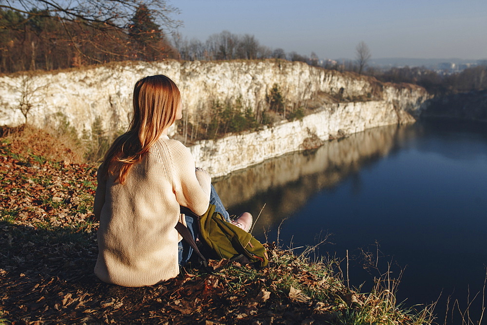 Caucasian woman sitting at the edge of reservoir