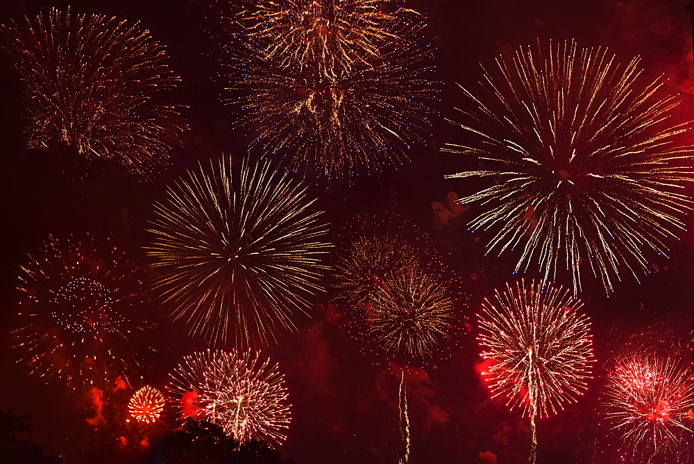 Fireworks exploding in red sky