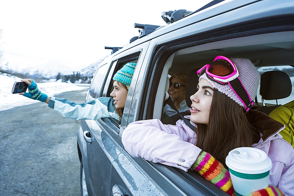 Friends photographing from car in winter