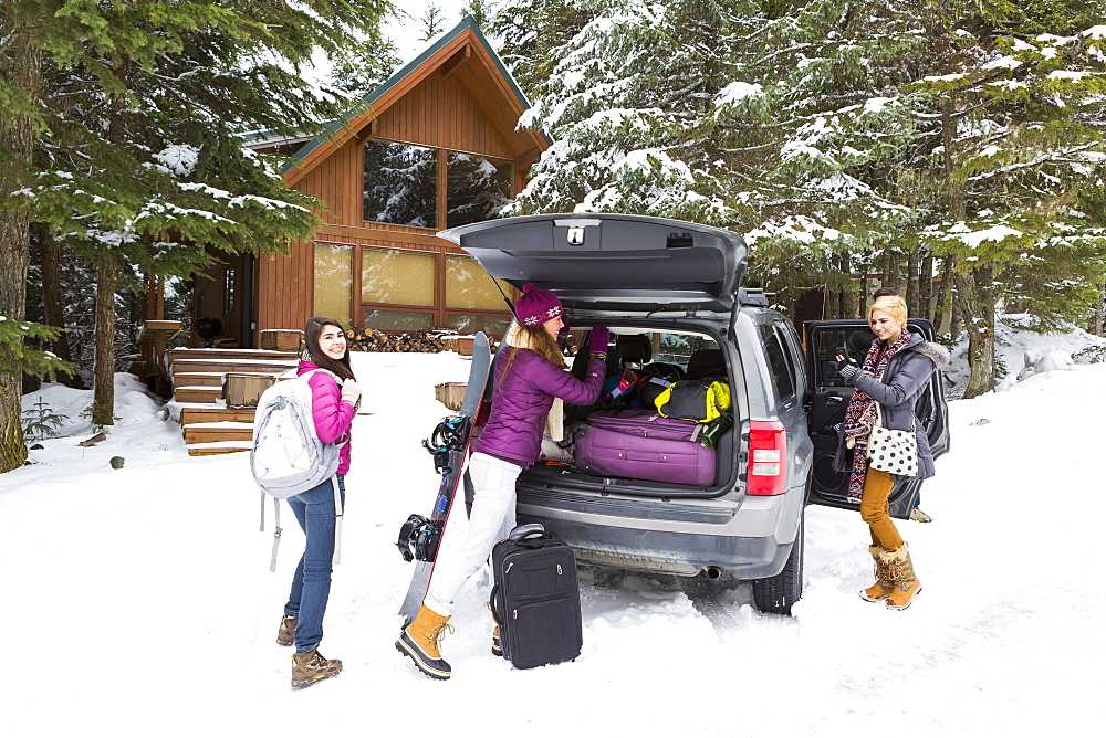 Friends unloading car at winter resort