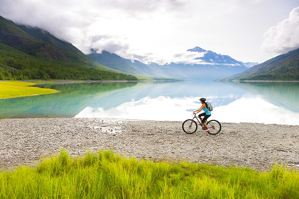 Mixed Race woman riding bicycle near lake