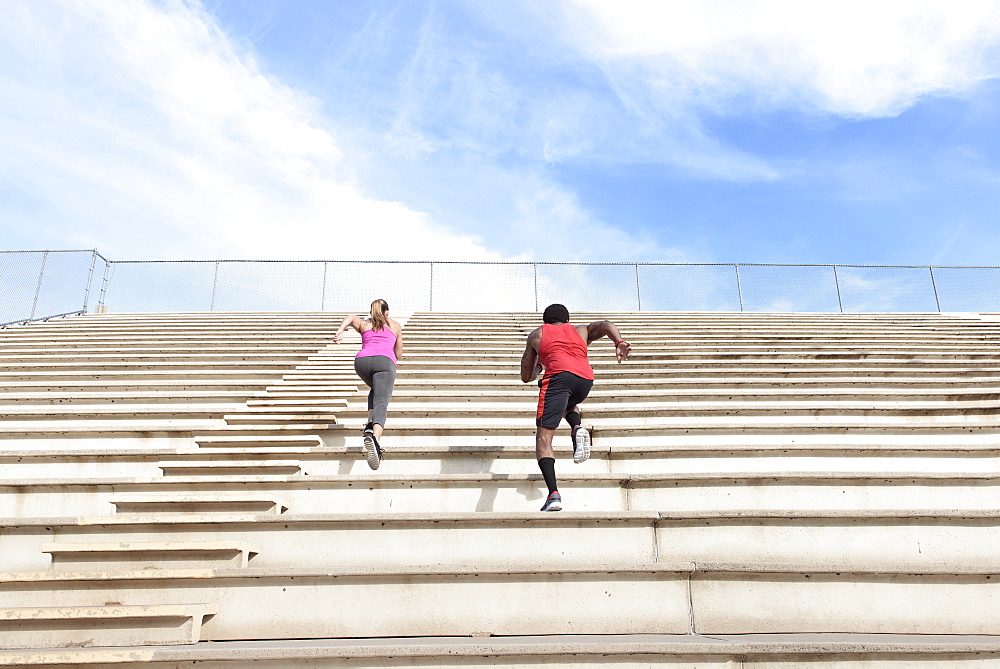 Man and woman running on bleachers