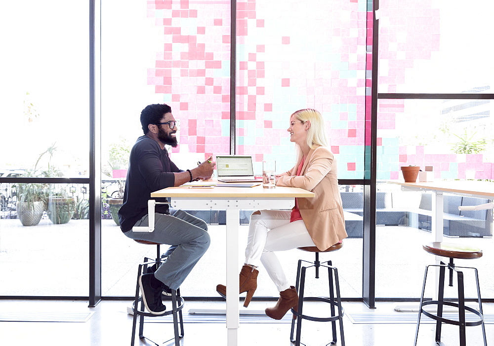 Creative business people talking at table with laptop