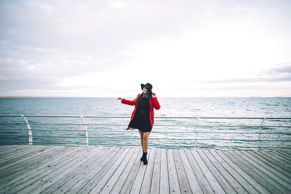 Portrait of carefree Caucasian woman standing on boardwalk