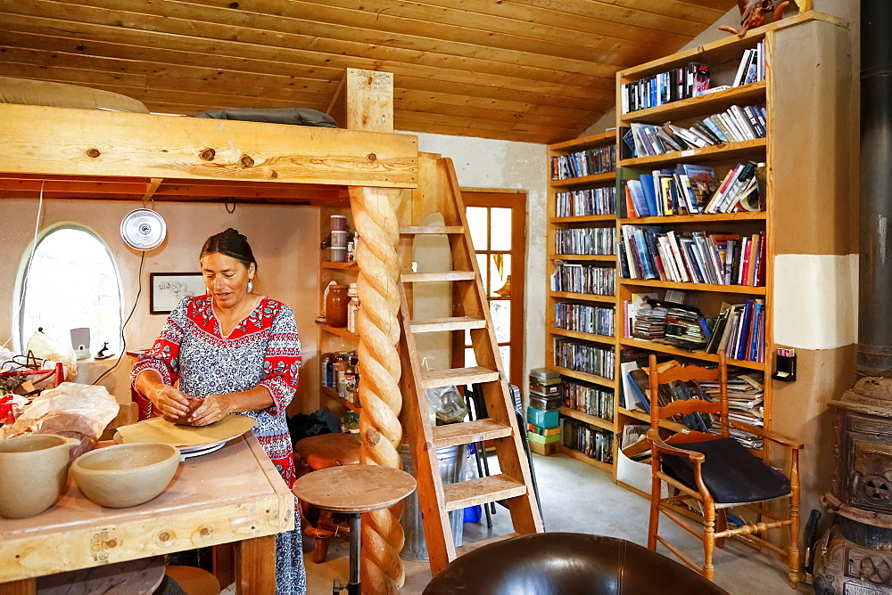 Mixed race woman shaping clay in art studio