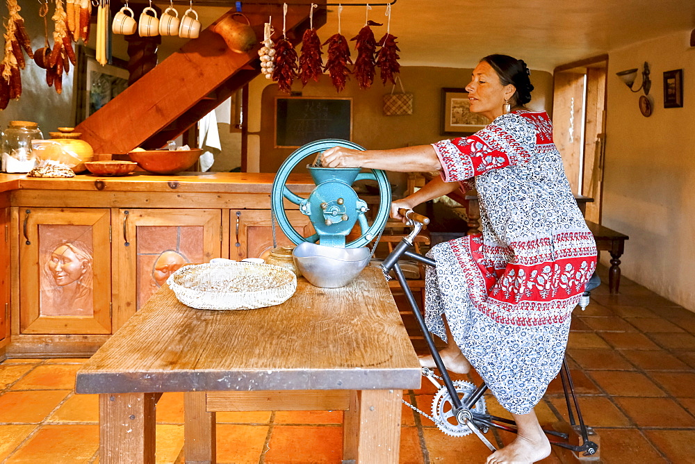 Woman pedaling to power grinder in kitchen