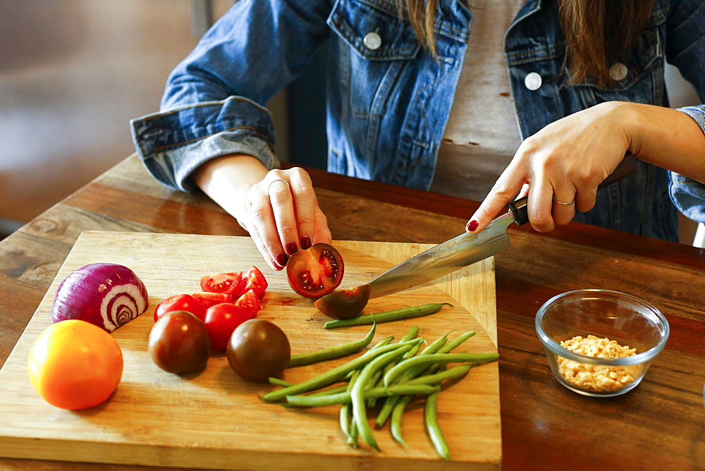 Woman chopping vegetables on cutting board