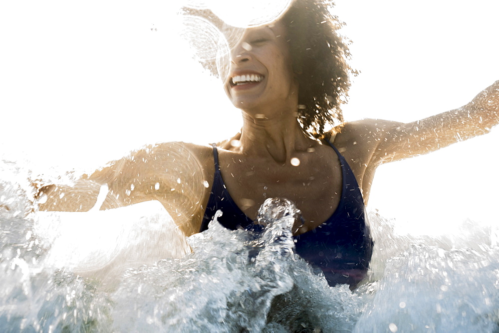 Ocean waves splashing on Mixed Race woman