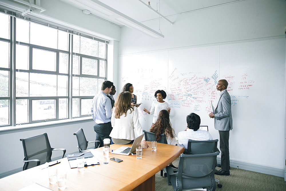 Businesswoman talking near whiteboard in meeting