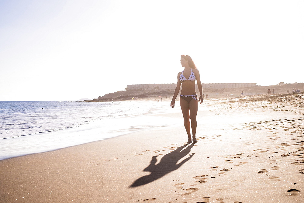 Caucasian woman walking on beach