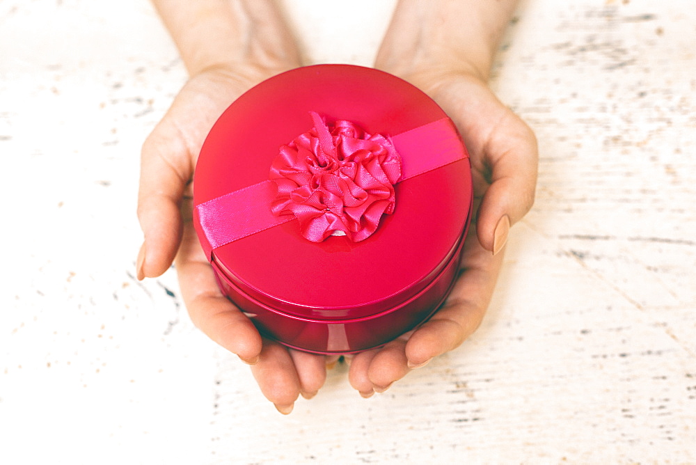 Hands of woman holding round gift box