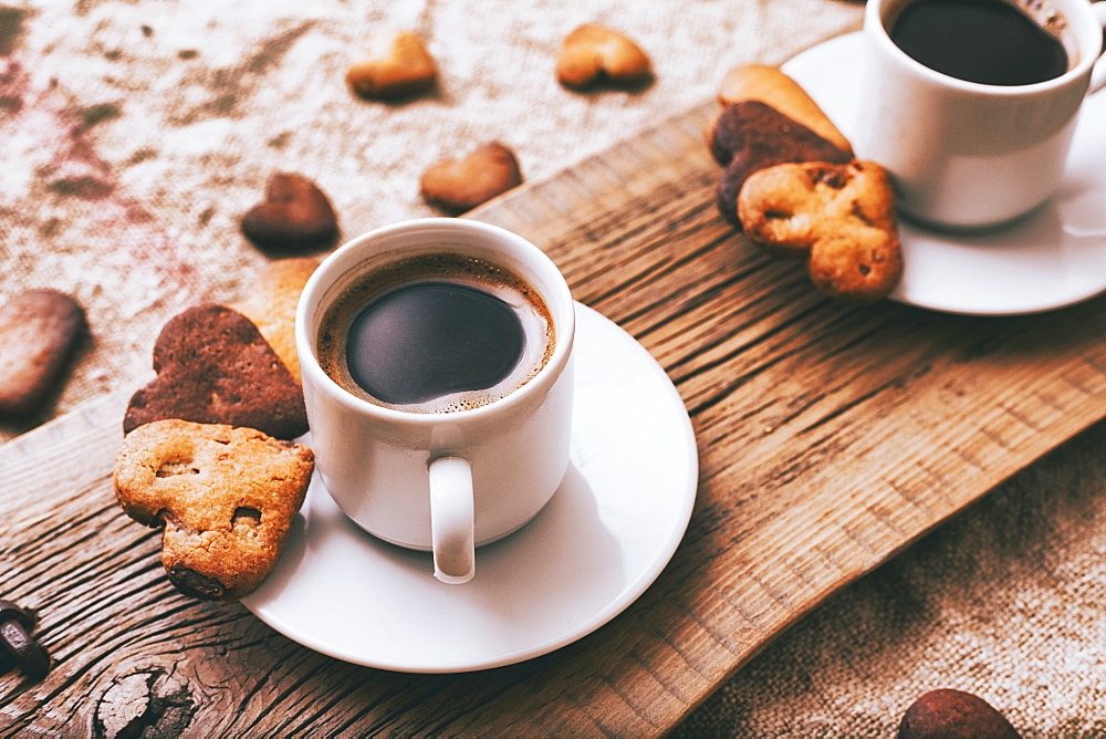 Coffee and heart-shape cookies on wooden tray