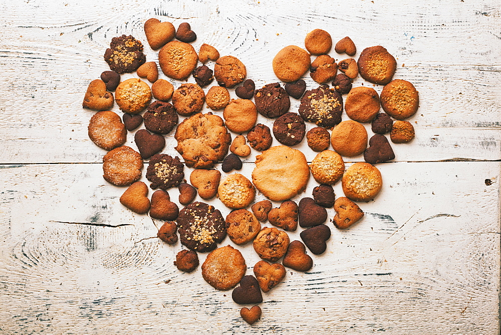 Variety of cookies on wooden table in heart-shape