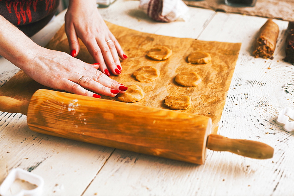 Hands of woman pressing cookie dough on baking sheet