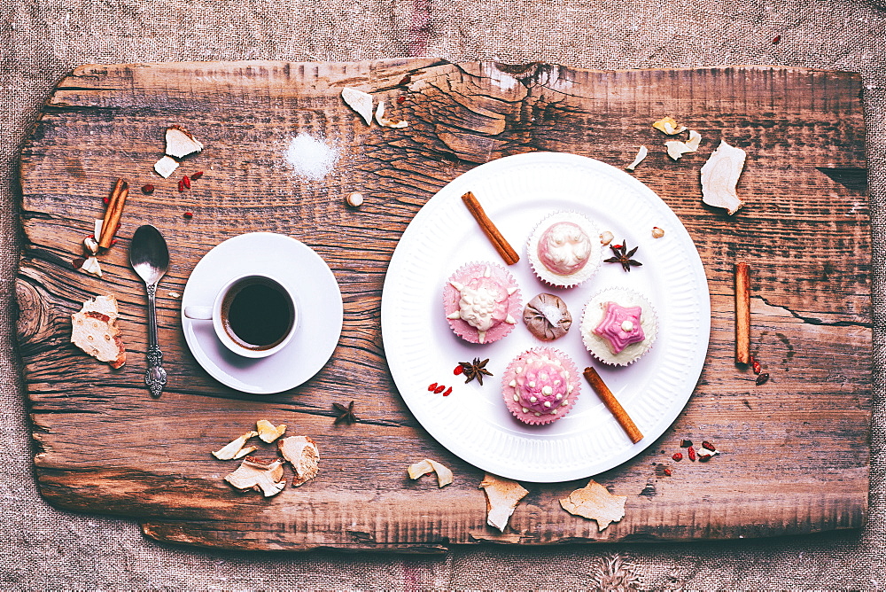 Cupcakes on ingredients on wooden tray with coffee