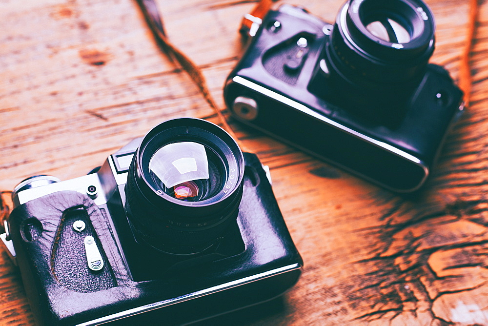 Cameras and straps on wooden table