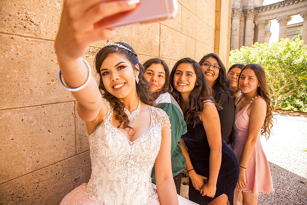 Hispanic girls posing for cell phone selfie