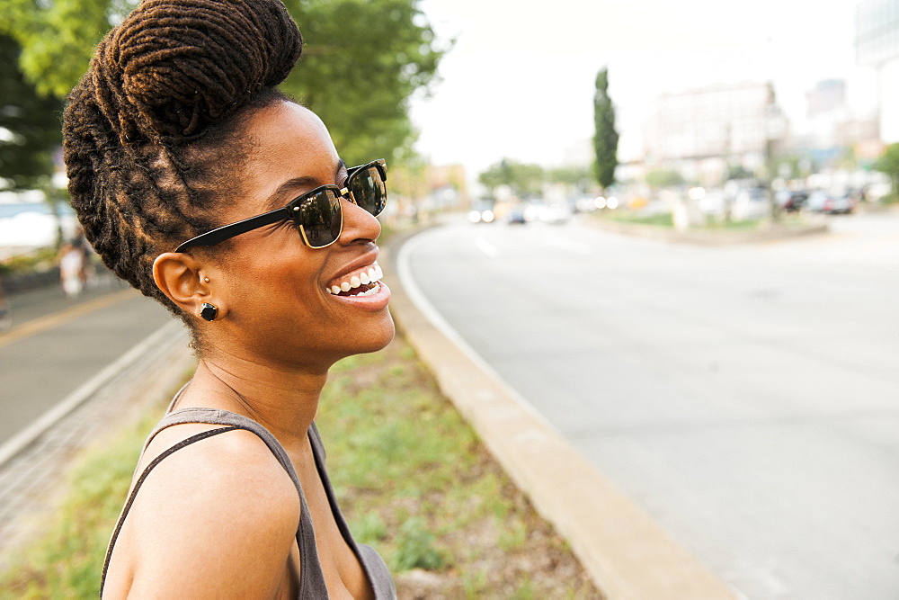 African American woman with braids laughing near street