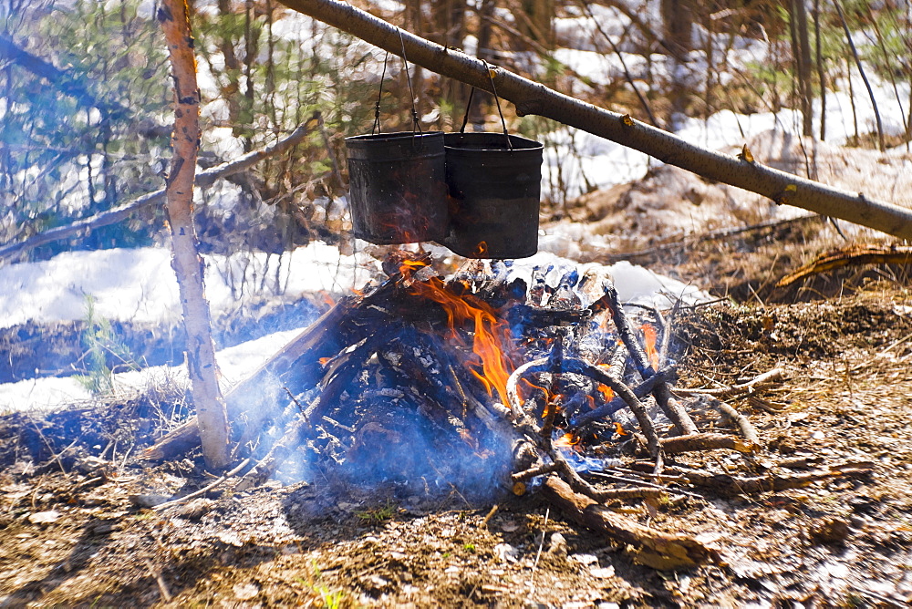 Food cooking in pots over a campfire