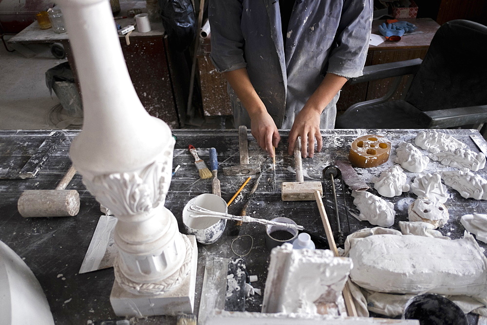 Hands of Caucasian sculptor holding tools