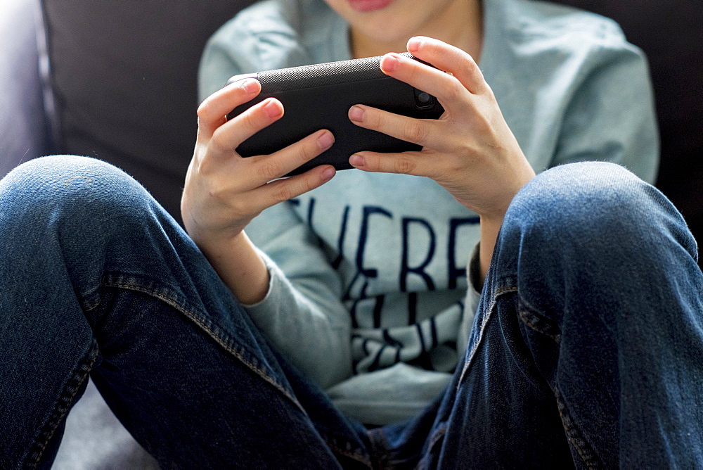 Close up of Caucasian boy playing with cell phone