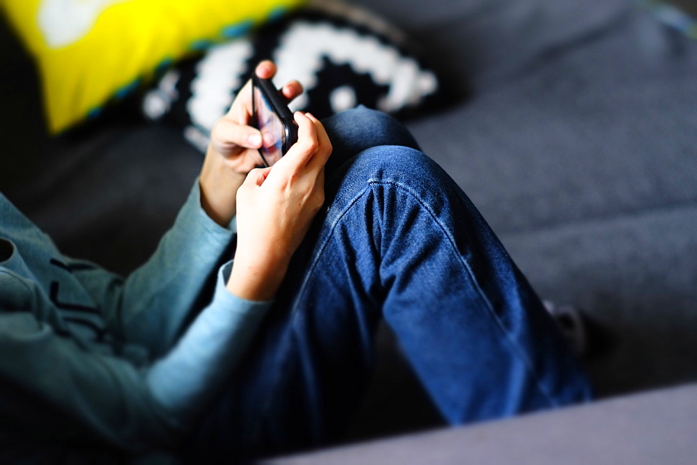 Close up of Caucasian boy playing with cell phone