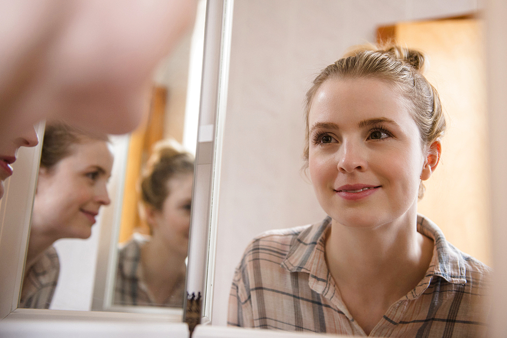 Smiling woman looking in mirror