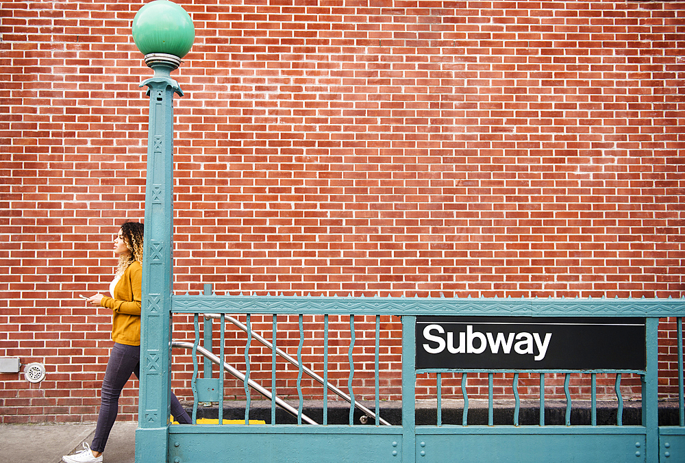 Mixed Race woman exiting subway station in city