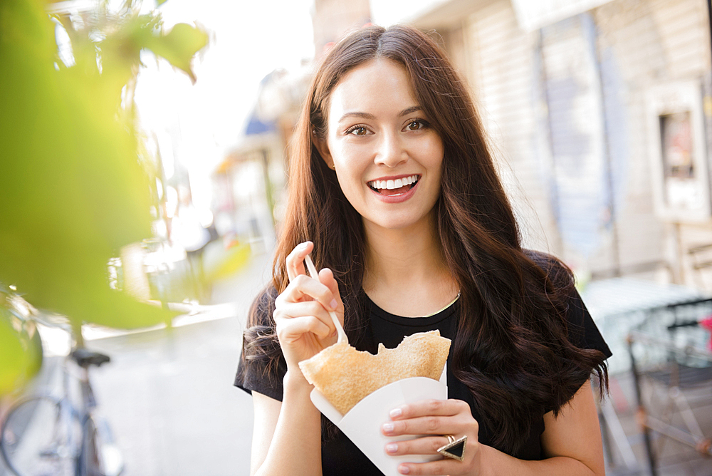 Thai woman eating food in city