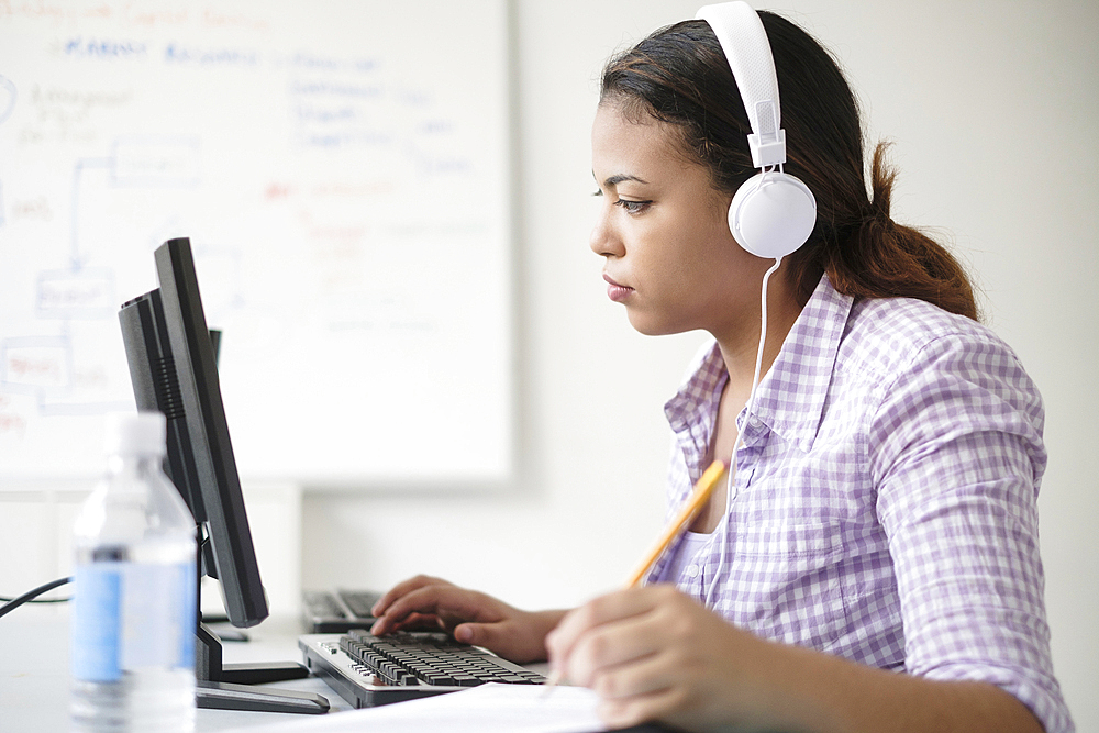 Hispanic woman typing in computer lab