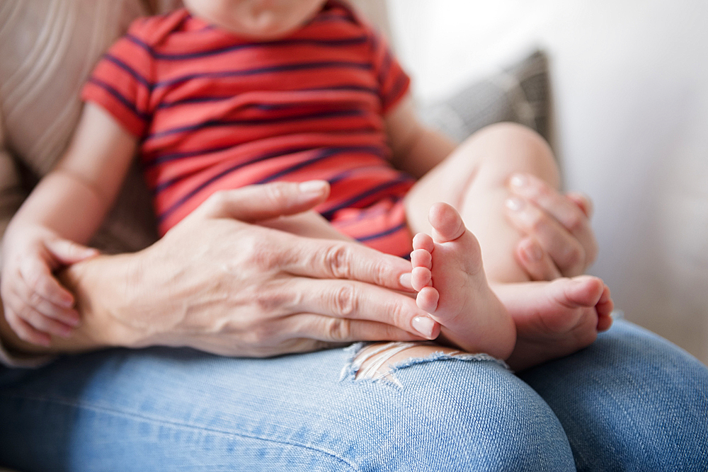 Caucasian mother holding baby son in lap