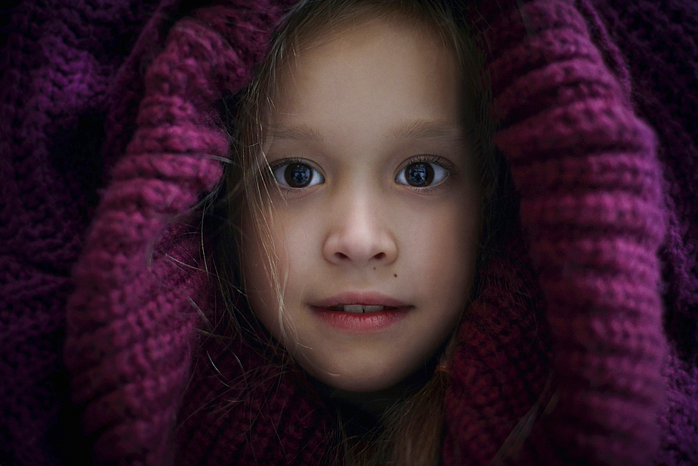 Portrait of Caucasian girl covering head with sweater