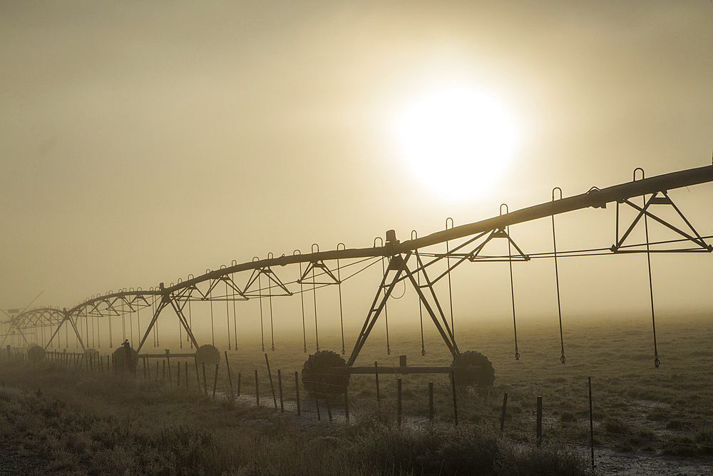 Irrigation equipment on farm in fog