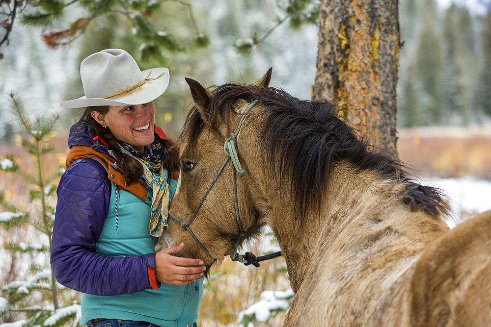 Caucasian woman petting horse in winter