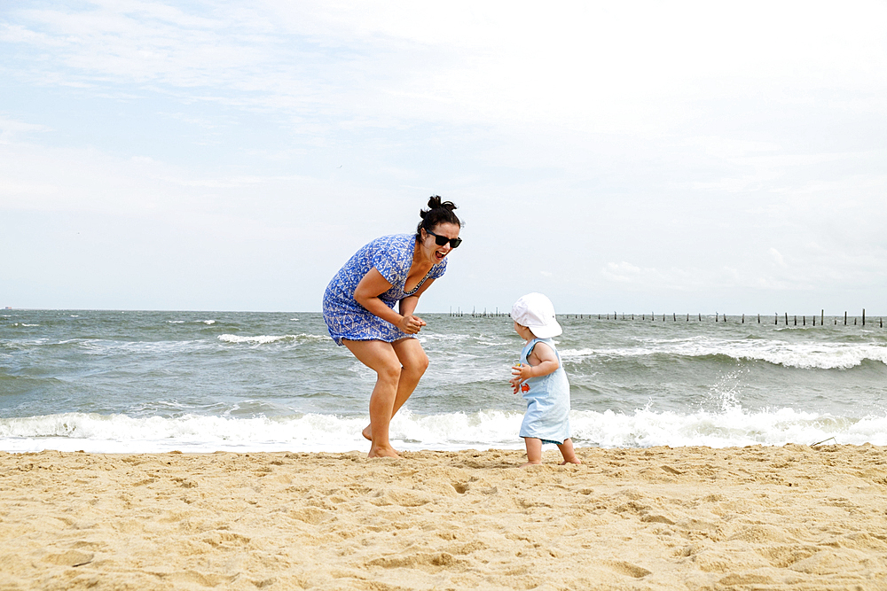 Caucasian mother and baby son playing at beach