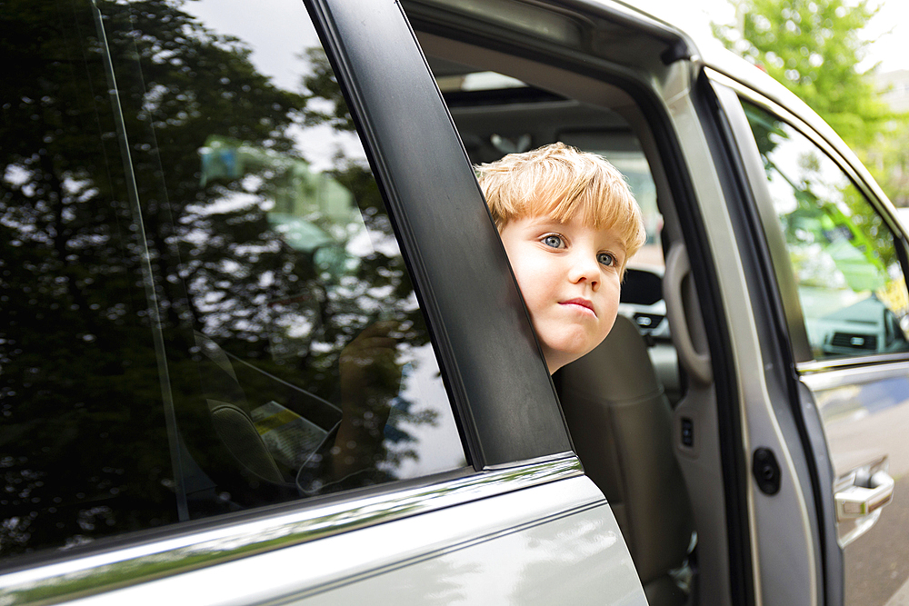 Caucasian boy waiting in mini-van