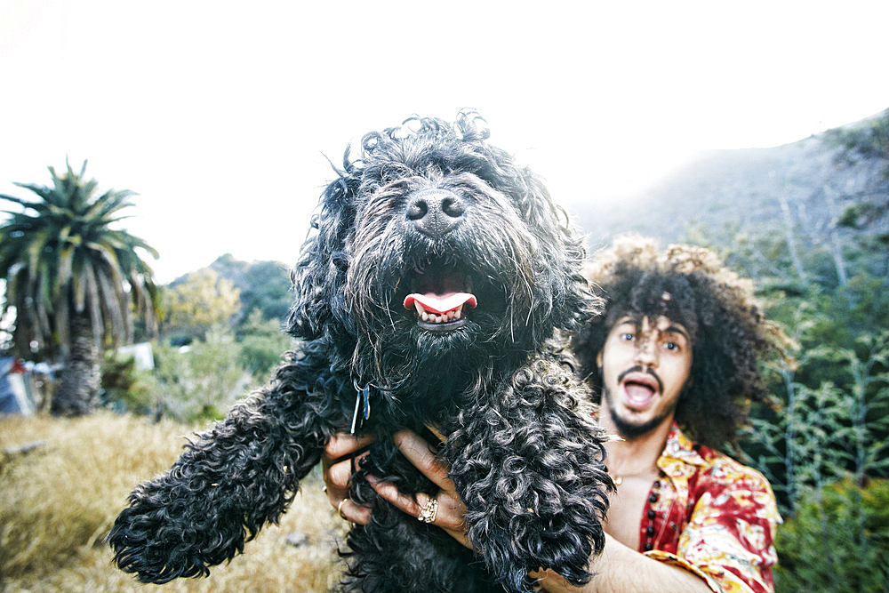 Mixed Race man holding shaggy dog