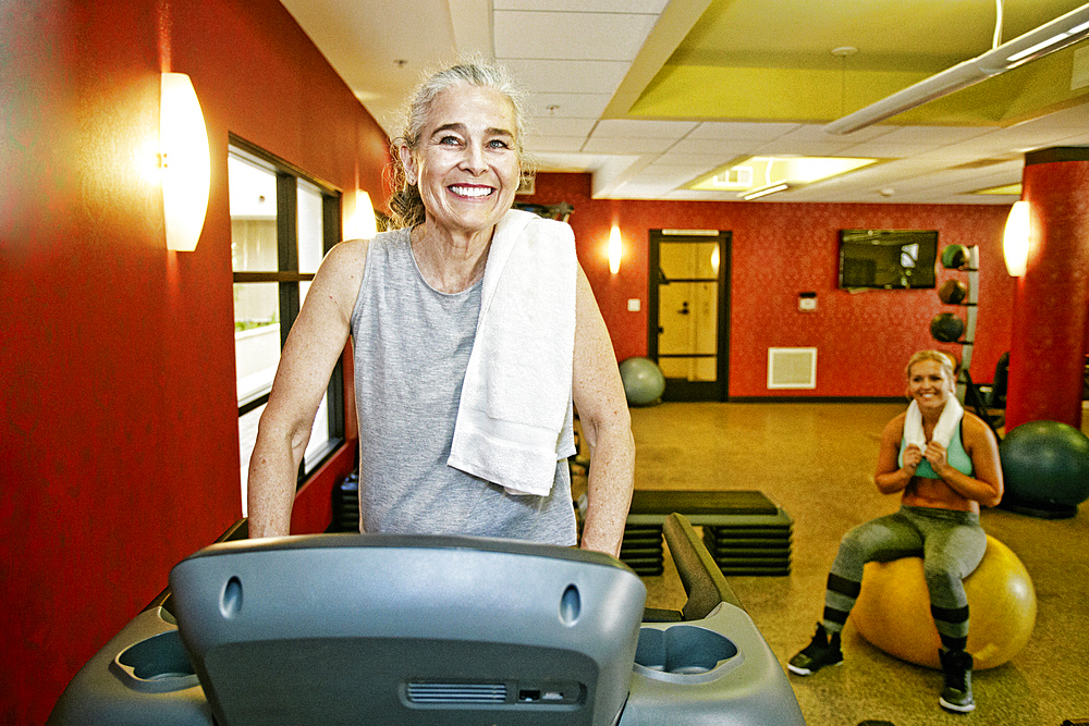 Smiling Caucasian mother and daughter in gymnasium