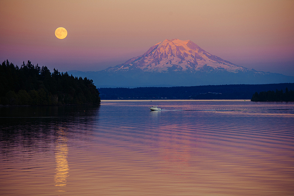 Boat in river near mountain under full moon