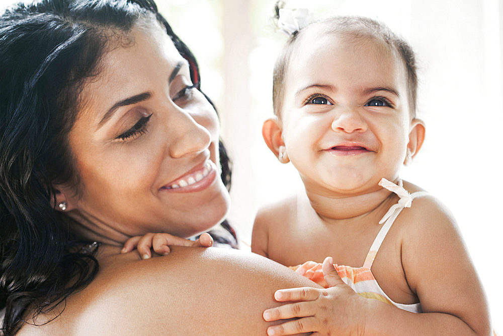 Mixed Race mother holding baby daughter