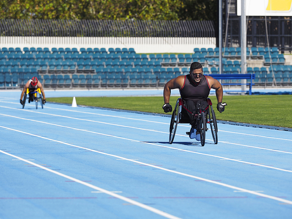 Middle Eastern man racing in wheelchair on track