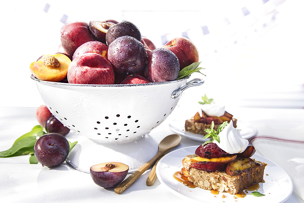 Bowl of fresh fruit in colander with dessert cake