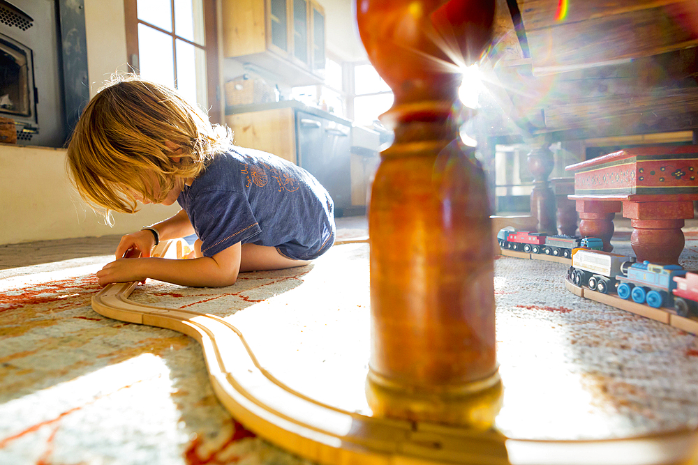 Caucasian boy playing with toy race track on floor