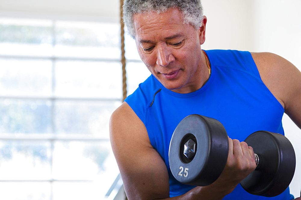 Mixed Race man curling dumbbell