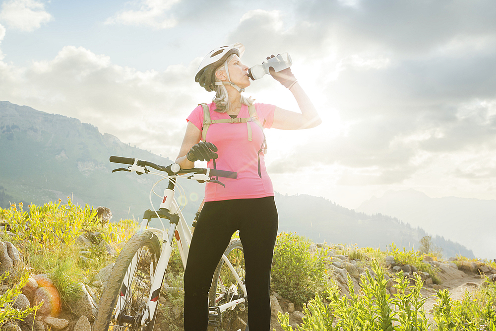 Caucasian woman with mountain bike drinking from bottle