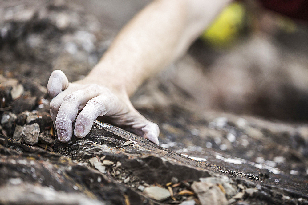 Hand of Caucasian man rock climbing